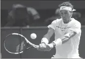  ??  ?? Rafael Nadal returns to Karen Khachanov during Friday’s match at the Wimbledon Tennis Championsh­ips in London.