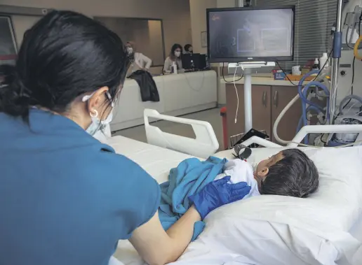  ??  ?? A nurse cares for a young patient watching TV at the hospital, in Istanbul, Turkey, April 16, 2021.