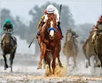  ?? ROB CARR / GETTY IMAGES ?? Justify, ridden by jockey Mike Smith, crosses the finish line towin the 144th running of the Kentucky Derby at Churchill Downs on Saturday in Louisville, Kentucky.