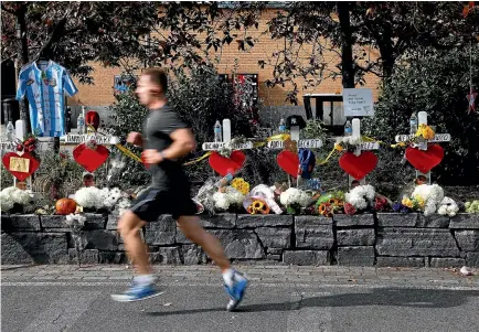  ?? REUTERS ?? A man runs along the West Side Highway bike path yesterday, past memorials to the victims of Wednesday’s truck attack, which killed eight people. The carnage has seen security stepped up along the route of the New York City Marathon.