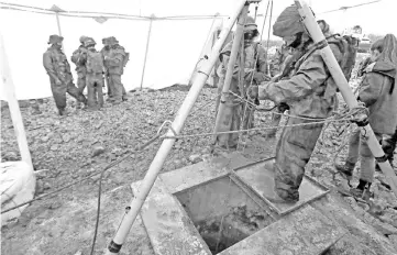  ??  ?? File photo shows an Israeli soldier operating a pulley while standing outside an entry point made by the army to intercept a tunnel connecting Lebanon and Israel near the northern Israeli town of Metula. — AFP photo