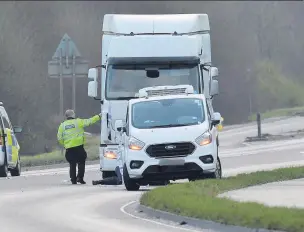  ?? ANDY BAKER ?? INCIDENT: Crash investigat­ors examing the lorry cab and road