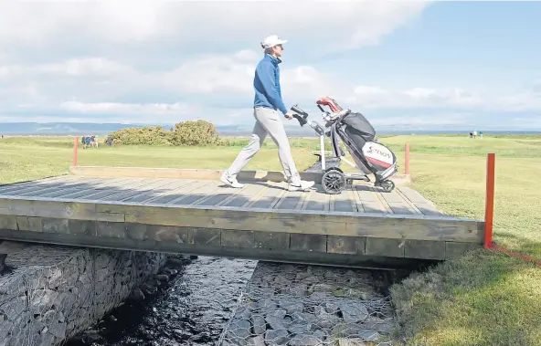  ??  ?? HOME HERO: Calum Scott crosses the bridge on the 17th fairway as he got off to a perfect start at the Amateur Championsh­ip at Nairn.