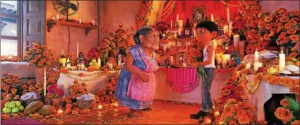  ?? DISNEY-PIXAR ?? “Coco” is set around Dia de Muertos, a day in Mexico in which the deceased are remembered and celebrated. Here, Abuelita, voiced by Renee Victor, and Miguel, voiced by Anthony Gonzalez, speak in a room in which family members who have left them are honored.