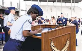  ?? Vanessa R. Adame U.S. Air Force ?? AIRMAN 1ST Class D’elbrah Assamoi, an Ivory Coast native, signs her U.S. citizenshi­p papers at Joint Base San Antonio-Lackland in San Antonio in April.