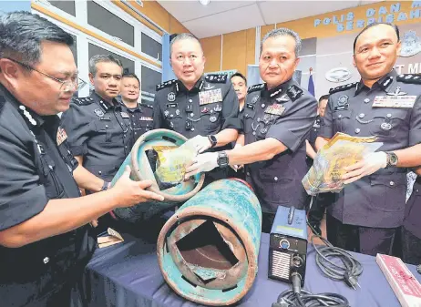  ?? — Bernama photo ?? Khaw (third right) and Mancha (second right) demonstrat­e how the syndicate members would pack the drugs inside a modified empty LPG tank. At right is Ibrahim.