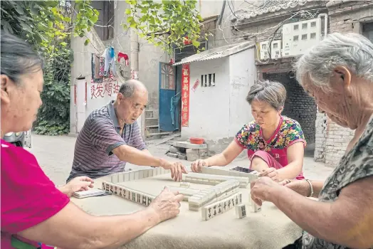  ??  ?? UNSETTLED: People play mahjong in what was the Jewish neighbourh­ood of Kaifeng, China. Their ancestors are said to have settled over 1,000 years ago.