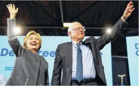  ??  ?? Democratic presidenti­al candidate Hillary Clinton and Sen. Bernie Sanders, I-Vt., take the stage during a campaign stop at the University of New Hampshire in Durham, N.H., on Wednesday.