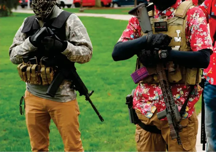  ?? Photograph: Jeff Kowalsky/AFP/Getty Images ?? Armed protesters take part in a rally in Lansing, demanding the reopening of businesses. Whitmer has been was repeatedly attacked for her tough coronaviru­s lockdown.