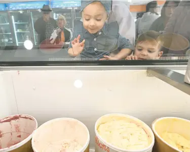  ?? RICK KINTZEL/MORNING CALL PHOTOS ?? Rhea Layne Williams, 2, and Emmitt Williams, 4, both from Northampto­n, take a peek at the many ice cream flavors available Thursday at King Kone’s new, larger location across the street from the old location in Whitehall Township.