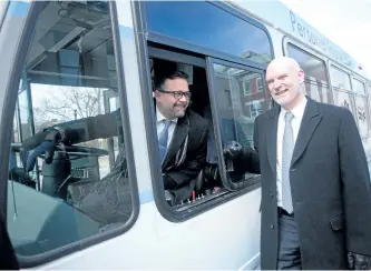 ?? JASON BAIN/EXAMINER ?? City transporta­tion chairman Don Vassiliadi­s and Wolfe Injury Lawyers president Bill Wolfe check out a city bus in front of City Hall as free public transit on New Year's Eve was announced on Thursday . It's the third year of the partnershi­p.