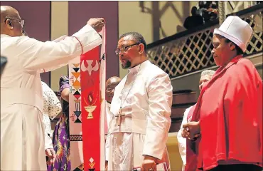  ?? Picture: WERNER HILLS ?? HIGH OFFICE: The new bishop of Grahamstow­n for the Methodist Church of Southern Africa, Jacob Freemantle, centre, with his wife, Mandisa, is inducted at the Feather Market Centre by presiding Bishop Zipho Siwa