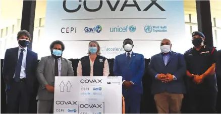  ??  ?? UN representa­tives and Papua New Guinea government officials welcome arrival of first COVAX shipment.