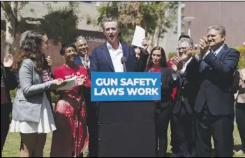  ?? ASSOCIATED PRESS ?? California Gov. Gavin Newsom (center) celebrates, Friday, in Santa Monica after singing a gun control law as he is surrounded by state officials including state Sen. Bob Hertzberg (right), state Sen. Anthony Portantino (second right), Attorney General Rob Bonta (third left) and gun violence survivors Mia Tretta and Arvis Jones.