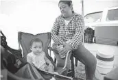  ?? ALEJANDRO TAMAYO U-T ?? Karina Amaya takes care of her neighbor’s baby while working at the street swap meet in Tijuana.