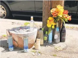  ?? LEA SKENE/BALTIMORE SUN ?? A memorial takes shape Friday afternoon for a young man killed overnight in Brooklyn. Police had not released his name.