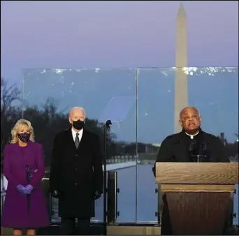  ?? ASSOCIATED PRESS ?? In this Jan. 19 file photo, President-elect Joe Biden and his wife, Jill, listen as Cardinal Wilton Gregory, Archbishop of Washington, delivers the invocation during a COVID-19 memorial at the Lincoln Memorial Reflecting Pool in Washington.