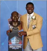  ?? PHOTO ?? LaDainian Tomlinson poses with a bust of himself during an induction ceremony at the Pro Football Hall of Fame on Saturday. AP