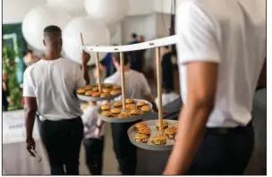  ?? The New York Times/DANIEL KRIEGERS ?? Traveling trays of sliders, meant to circulate at a wedding, were made by Pinch Food Design June 8 in New York.