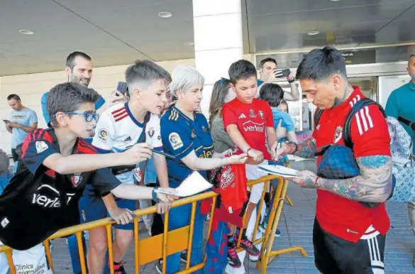  ?? ?? El argentino Chimy Ávila firma unos autógrafos antes de subirse al autobús al llegar al aeropuerto de Noáin.