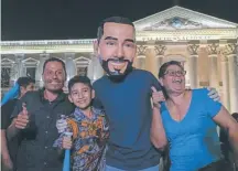  ?? / AP ?? Una familia posa junto a “Bukele”, frente al Palacio Nacional de El Salvador.