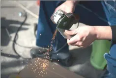  ??  ?? Geng Shuai cuts a piece of stainless steel to craft a cellphone case.