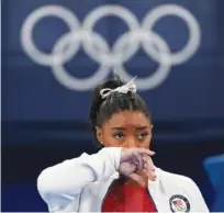  ?? AP PHOTO/ASHLEY LANDIS ?? Simone Biles, of the United States, watches gymnasts perform Tuesday at the 2020 Summer Olympics in Tokyo. Biles says she wasn’t in the right headspace to compete and withdrew from gymnastics team final to protect herself.