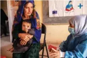  ?? SAVE THE CHILDREN VIA AP ?? A Save the Children counsellor, right, explains to Nelab, 22, how to feed her 11-month-old daughter, Parsto, with therapeuti­c food Sept. 29 in Sar-e-Pul province of Afghanista­n.