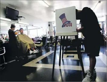  ?? Anne Cusack Los Angeles Times ?? MARCO GARCIA casts his ballot for the 2014 primary in a Long Beach barbershop. Registrati­on forms have been redesigned after many voters confused the American Independen­t Party with being unaffiliat­ed.