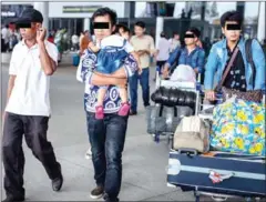  ?? CENTRAL ?? Four migrants and a 1-year-old girl arrive at the Phnom Penh Internatio­nal Airport after living in Malaysia without pay.