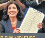  ?? REUTERS ?? New York Governor Kathy Hochul shows a signed package of bills on gun control during a bill signing ceremony in the Bronx.