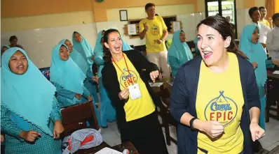  ?? DIPTA WAHYU/JAWA POS ?? KOMUNIKASI AKTIF: Mahasiswa fasilitato­r asal Amerika Serikat, Robyn Stewart (kanan) dan Alicia Bradley, bermain bersama siswa-siswa SMP Khadijah Surabaya dalam rangkaian program Camp EPIC kemarin (19/1).