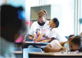  ?? NAM Y. HUH/AP ?? A teacher works with a student at Chalmers Elementary in Chicago.