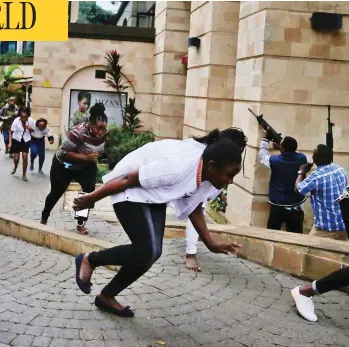  ?? KHALIL SENOSI / THE ASSOCIATED PRESS ?? Civilians flee as security forces aim their weapons at a hotel complex in Nairobi, Kenya, Tuesday, after Islamic extremists stormed the building. One police officer said he saw bodies, “but there was no time to count the dead.”