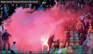  ??  ?? Angry scenes: Flares are thrown in the stands