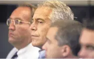  ?? UMA SANGHVI/PALM BEACH POST ?? Jeffrey Epstein, center, is shown in custody in West Palm Beach, Fla., in 2008. The wealthy financier has been arrested in New York on sex traffickin­g charges.