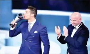  ?? FABRICE COFFRINI/ AFP ?? Cristiano Ronaldo kisses the trophy after winning the Best FIFA Men’s Player of 2016 Award next to FIFA president Gianni Infantino on Monday in Zurich.