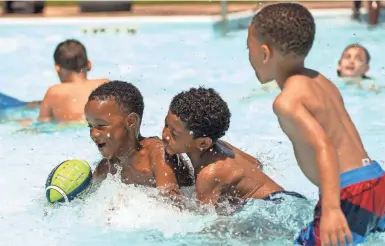  ?? CHLOE TROFATTER/SOUTH BEND TRIBUNE ?? Robert Stucky, 7, plays football in the splash pad with his friends Braylen Wilderness, 6, and Kaden Reid, 6, on June 14, 2022 at Kennedy Park in South Bend.