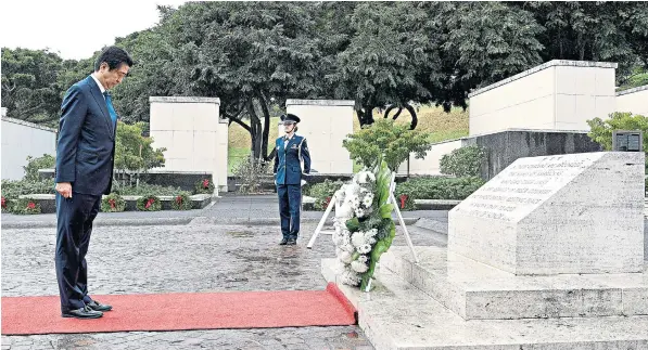  ??  ?? Japan’s Prime Minister Shinzo Abe presents a wreath at the National Memorial Cemetery of the Pacific in Honolulu, Hawaii, yesterday. He was today due to visit Pearl Harbour with US President Barack Obama and Michelle Obama