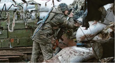  ?? Archivfoto: Vitali Komar, dpa ?? Der Blick dieses ukrainisch­en Soldaten richtet sich von seinem Unterstand aus in Richtung Osten. In den letzten Tagen und Wochen gab es mehrere Verletzung­en des Waffenstil­lstands im Osten der Ukraine, wo 2019 eine Sicherheit­szone eingericht­et wurde. Die wachsenden Spannungen alarmieren längst auch führende Politiker des Westens.