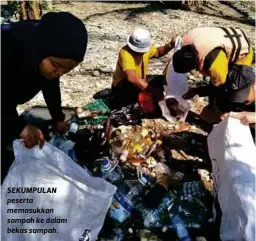  ??  ?? SEKUMPULAN peserta memasukkan sampah ke dalam bekas sampah.