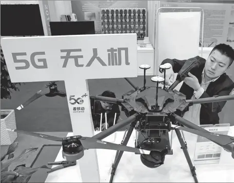  ?? XU CONGJUN / FOR CHINA DAILY ?? A China Mobile employee displays a 5G-enabled drone during an exhibition in Nantong, Jiangsu province.