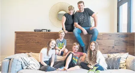  ?? CARLOS OSORIO/TORONTO STAR ?? Shea Warrington and her husband, John Scoffield, with their kids, from left, Mattie, twins Johnnie and Chace, and Jess. Behind the half-wall is a Scoffield’s design creation, “a mud room hidden in plain sight,” Warrington says.
