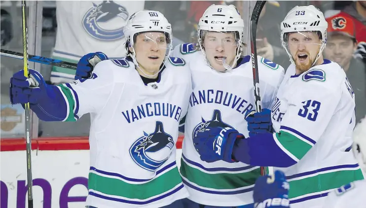  ?? — THE CANADIAN PRESS FILES ?? Vancouver’s Brock Boeser, centre, celebrates his goal with Markus Granlund, left, and Henrik Sedin in a game against the Flames in Calgary on Saturday.