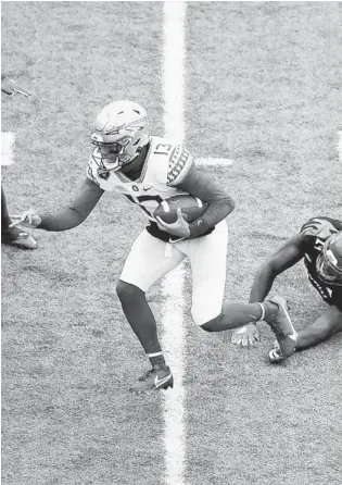  ?? ANDY LYONS/GETTY ?? Florida State quarterbac­k Jordan Travis scrambles for a touchdown against Louisville on Saturday.