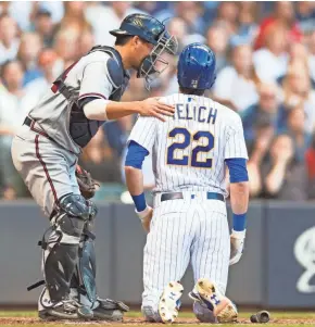  ?? JEFF HANISCH / USA TODAY SPORTS ?? Braves catcher Kurt Suzuki checks on Brewers centerfiel­der Christian Yelich after Yelich was hit by a pitch during the third inning.