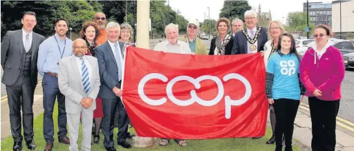  ??  ?? ●●The Co-operative flag being raised outside Rochdale town hall to mark the start of Co-operative Fortnight