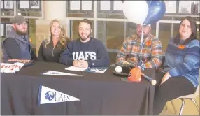  ?? Westside Eagle Observer/SUSAN HOLLAND ?? Mason Dagley flashes a big smile after signing his letter of intent Thursday, Nov. 14, to play college baseball for the University of Arkansas at Fort Smith. Dagley, who has been a three-year starter for the Gravette Lions’ baseball team and earned allconfere­nce honors last season, is joined by Rick Bray, his mother Tabitha Dagley, his father Allen Dagley and Kimberly Dagley.