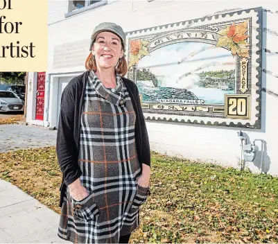  ?? BOB TYMCZYSZYN TORSTAR ?? Artist Elaine Wallis with the mural she painted at St. Lawrence Avenue and Queen Street in Niagara Falls.