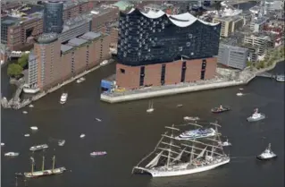  ?? FRANK BRUENDEL, THE ASSOCIATED PRESS ?? Tall ships pass by the billion-dollar Elbphilhar­monie concert hall, an architectu­ral gem in the Hamburg harbour.